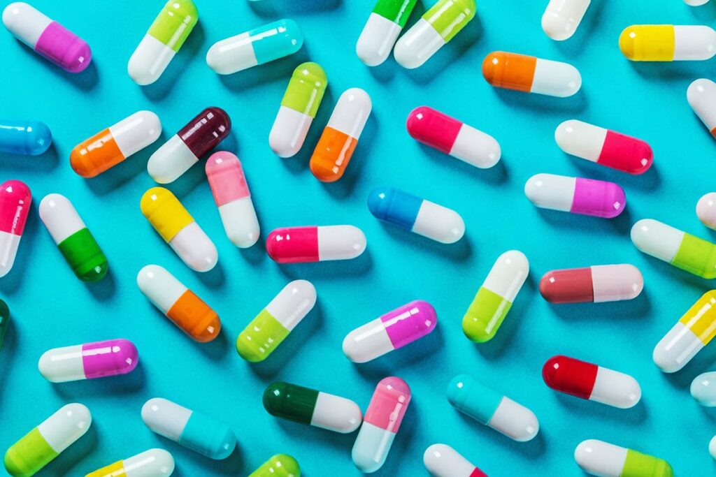 an assortment of brightly colored pills on a bright blue background