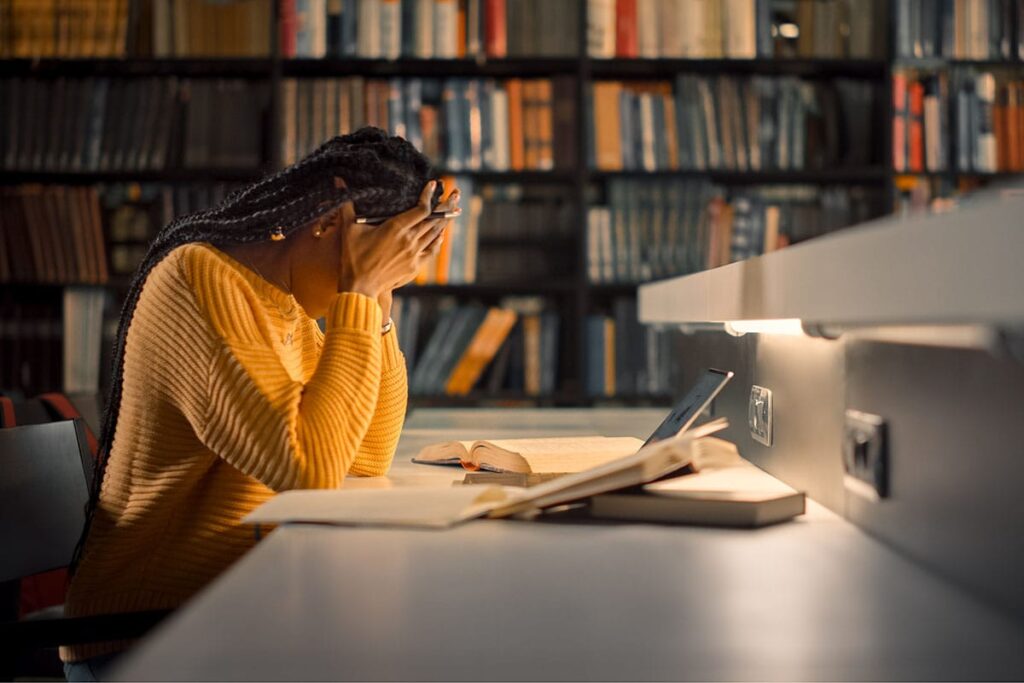 a college student struggles to stay focused studying in the campus library as a result of the effects of her recent binge drinking and partying