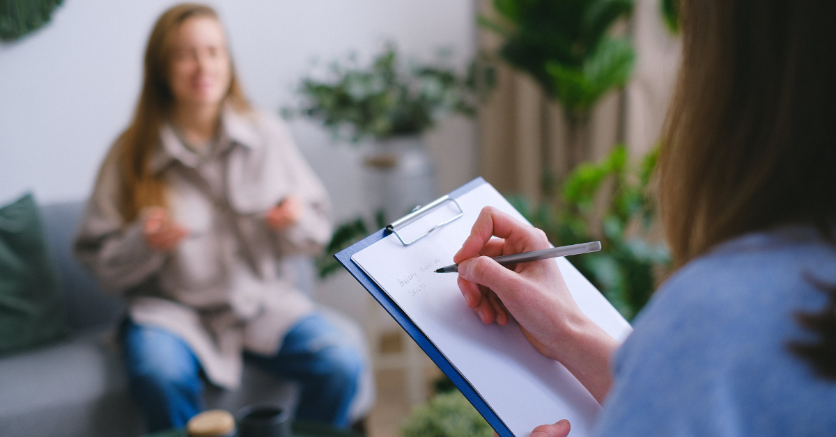 A woman talking to a therapist receiving heroin addiction treatment