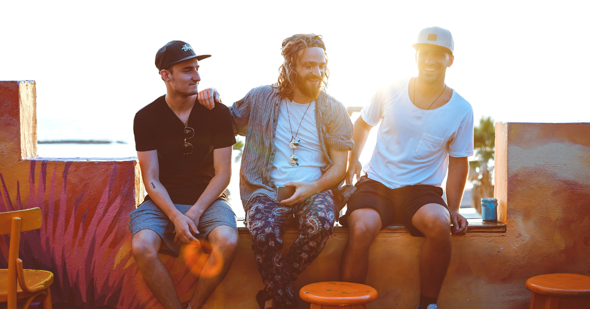 Three men sitting on the roof of a building laughing, they are all in each others sober support networks