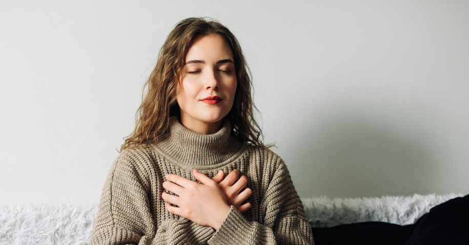 Woman with arms crossed over chest practicing a ground coping skill in recovery