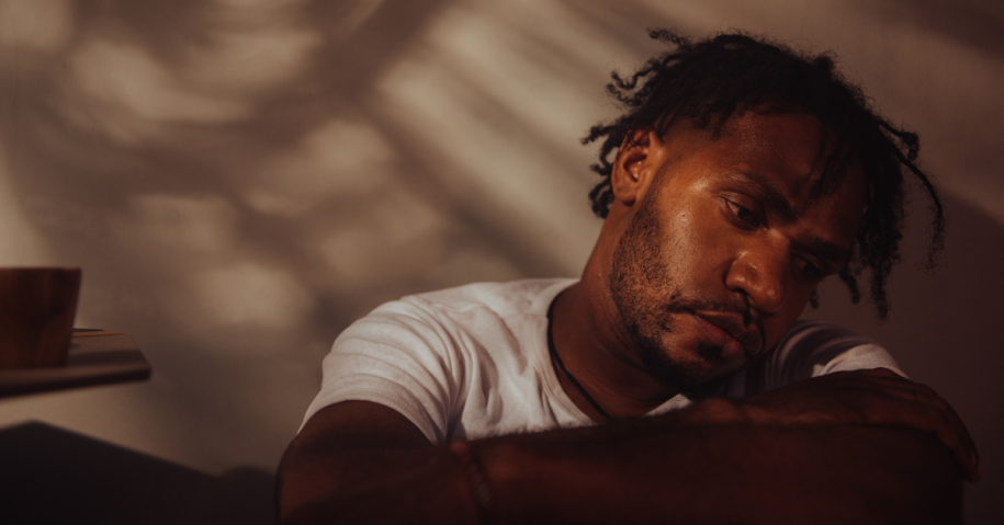 A man looking sad, using addiction as a coping mechanism.